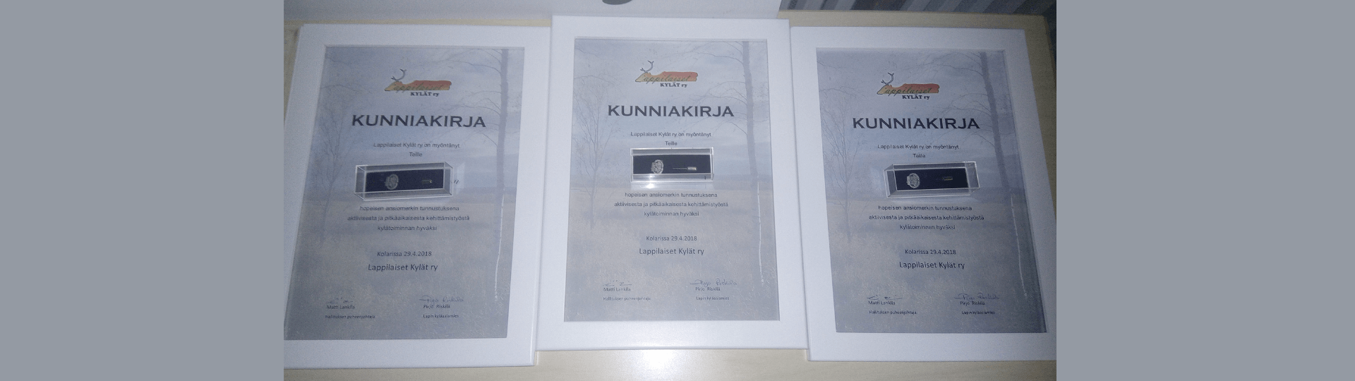 kolme kunniakirjaa ja ansiomerkit